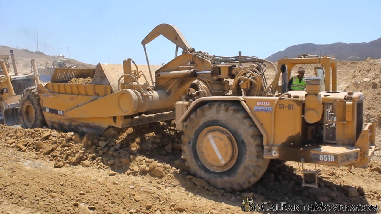 CAT 651B scrapers removing rocky hump