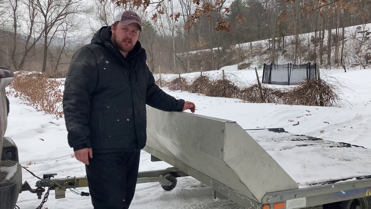 Loading and unloading snowmobile on tilt trailer