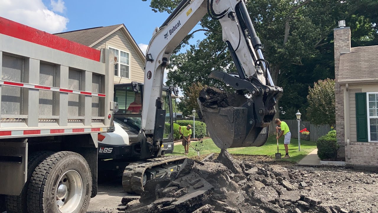 Bobcat E85 excavator ripping asphalt and loading trucks