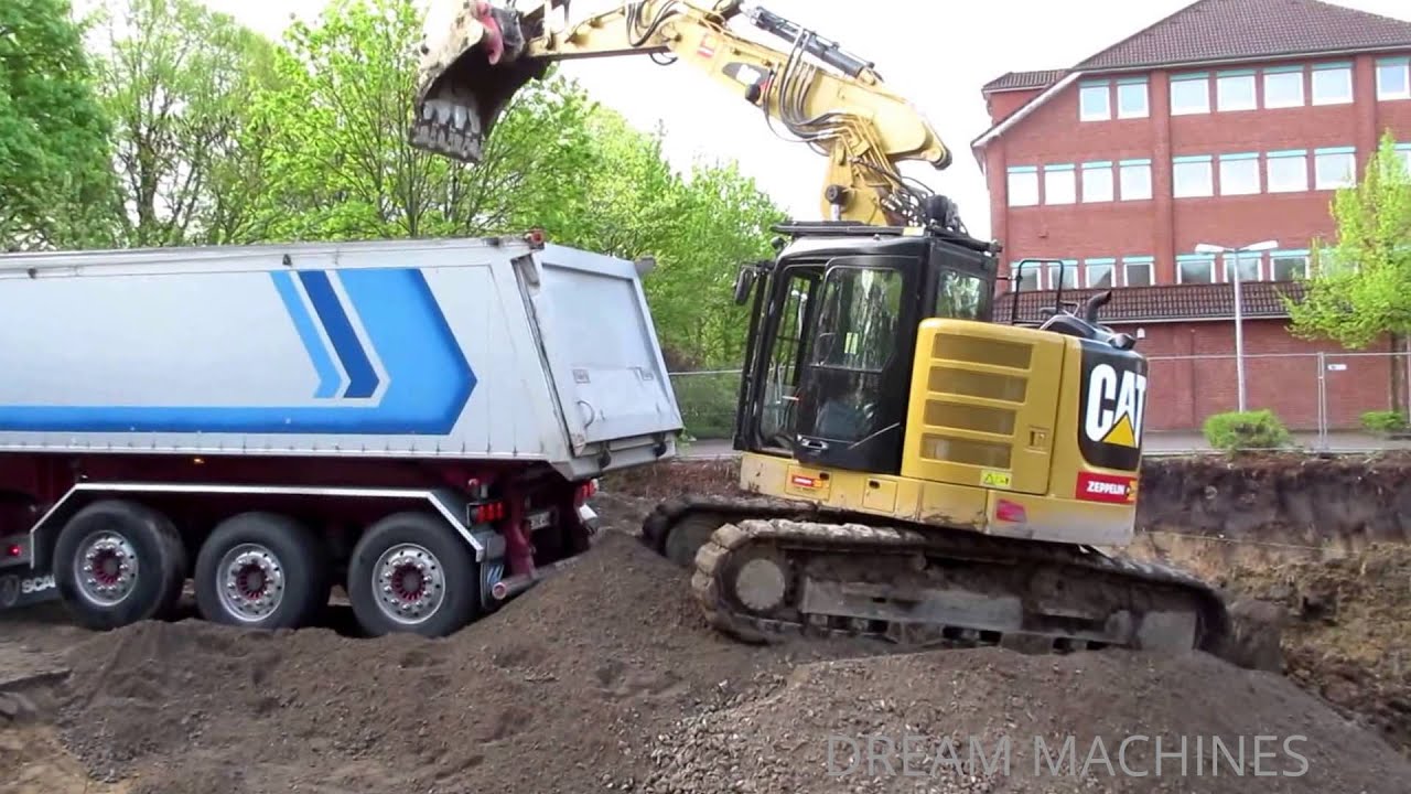 CATERPILLAR 314E BAGGER AUF BAUSTELLE BELADEN MULDENKIPPER
