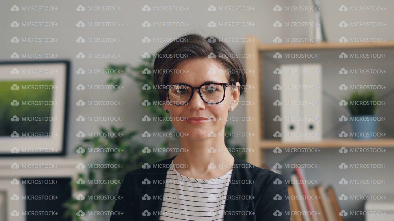 Portrait of beautiful young woman smiling looking at camera standing in office