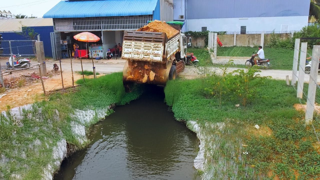 Landfill Project: Dump Truck Dumping dirt to Delete Flooded, Bulldozer Pushing