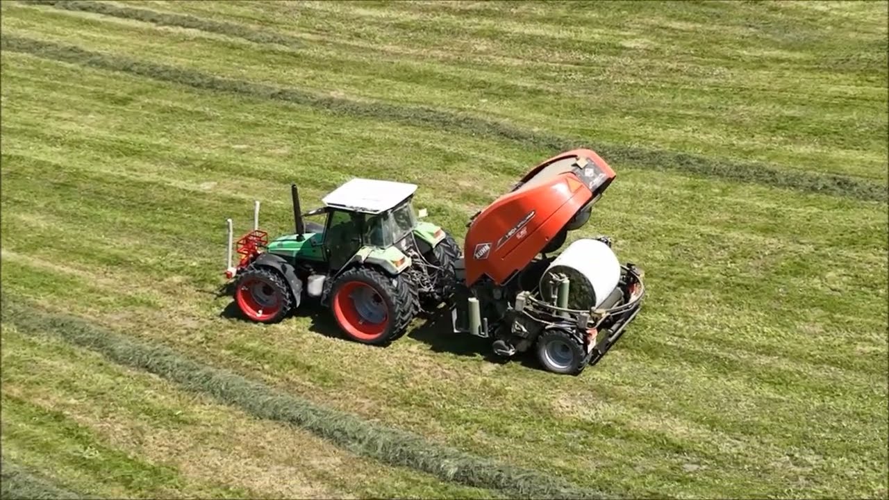 Kuhn Presswickelkombi I-BIO fährt Lukas und Remo führt die Ballen mit dem Traktor zusammen.