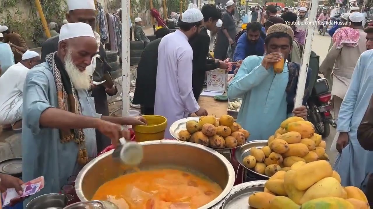 Hardworking old Man Making mango juce/ice Mango milk shake/ street food 