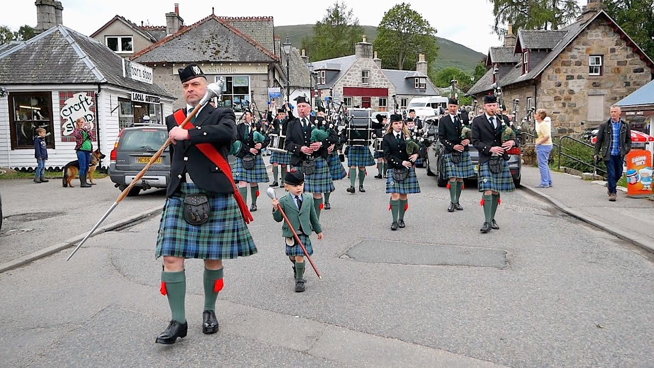 Drum Major Ias Esson has help leading Ballater Pipe Band marching through Braemar in Scotland 2019