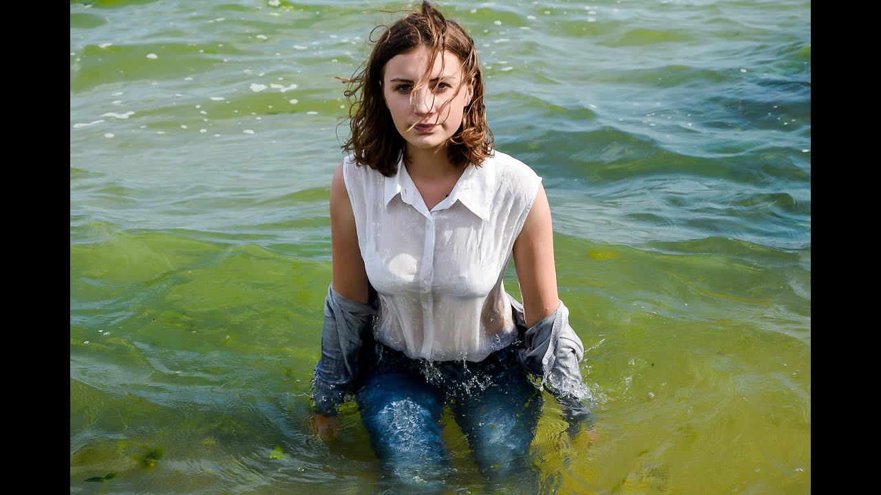 tender girl poses beautifully in wet clothes on the seashore for wetlook video