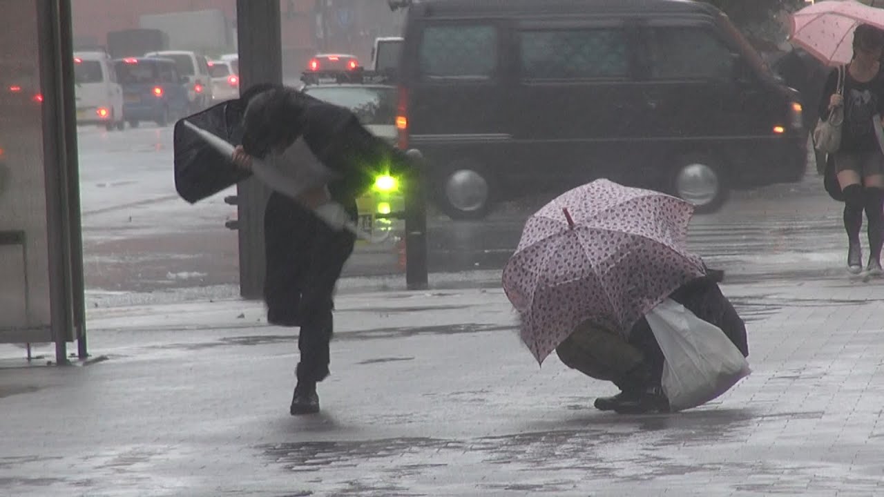 台風18号暴風雨に座り込む女性。The woman who was not able to endure the rainstorm of the typhoon.