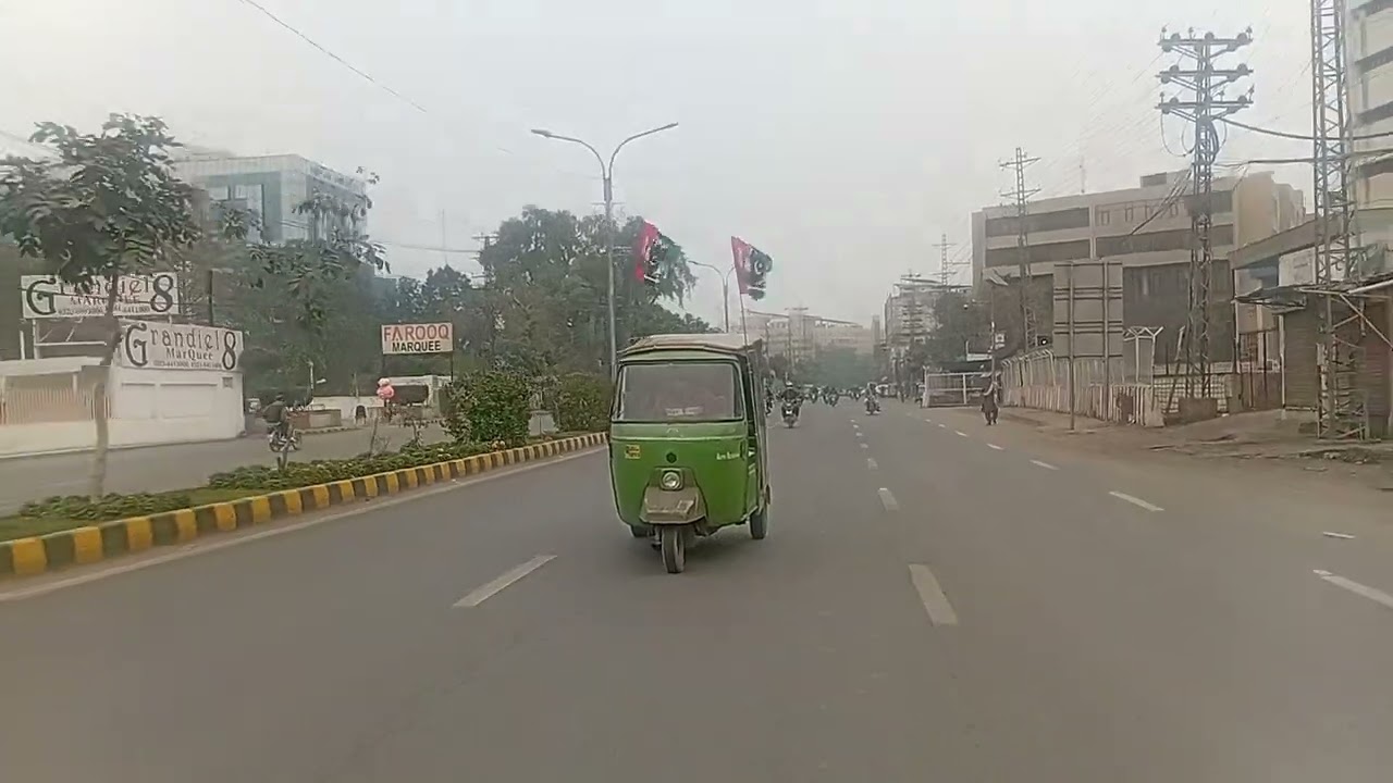 A rickshaw moving on a road in Lahore, Punjab, carrying Pakistan Peoples Party (PPP) flags.