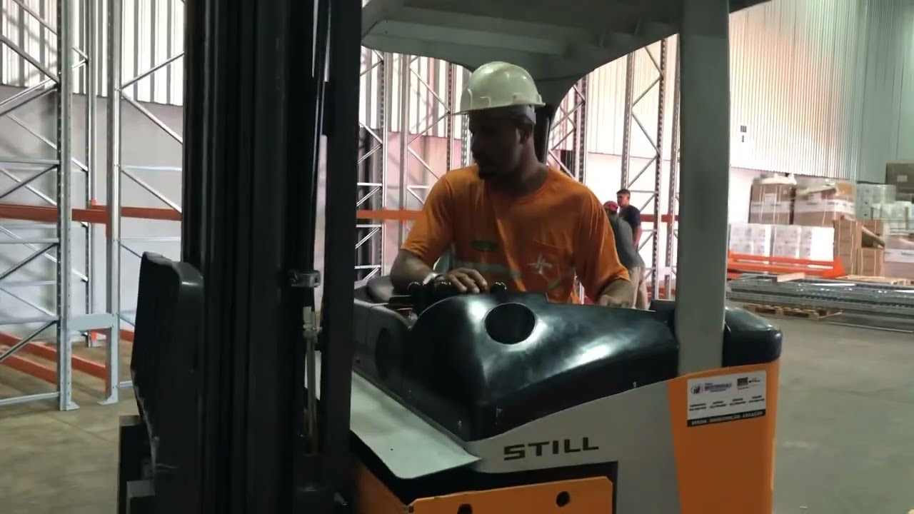 Aula prática empilhamento de cargas com empilhadeira elétrica de mastro retrátil.