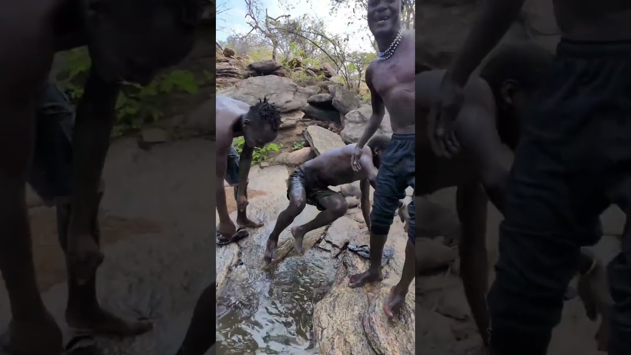 Hadza tribe people enjoy bathing in rainwater