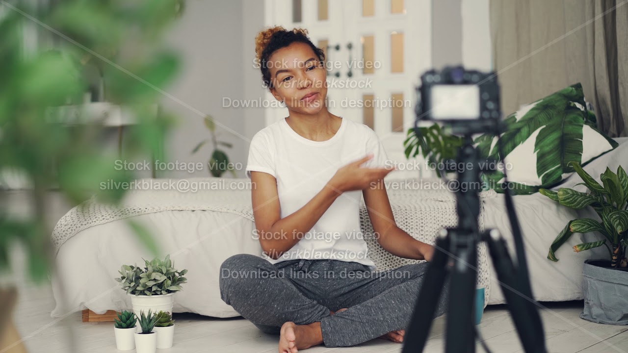 Happy African American woman vlogger is recording video for online blog, she is looking at camera