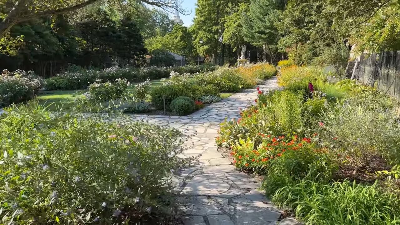 A terraced garden with fountains, lotus ponds, herbaceous borders, statues, marble benches, & more