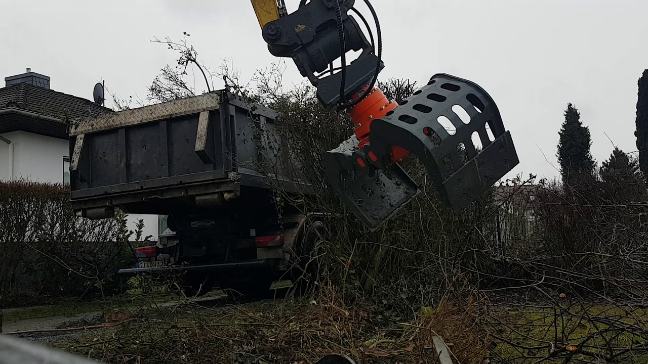 Mit dem Bagger und dem neuen Greifer Hecke entfernt