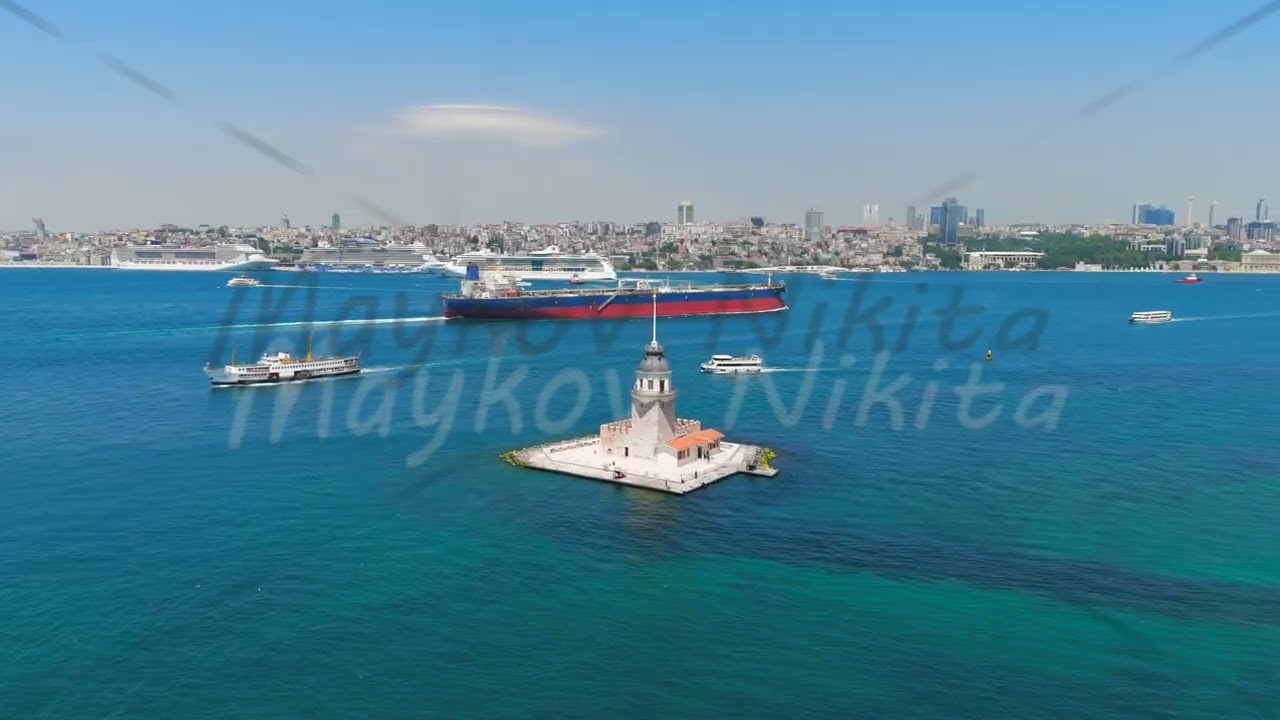 Istanbul, Turkey. Maidens Tower Kiz Kulesi with cargo ship and cruise liners sailing on Bosphorus...