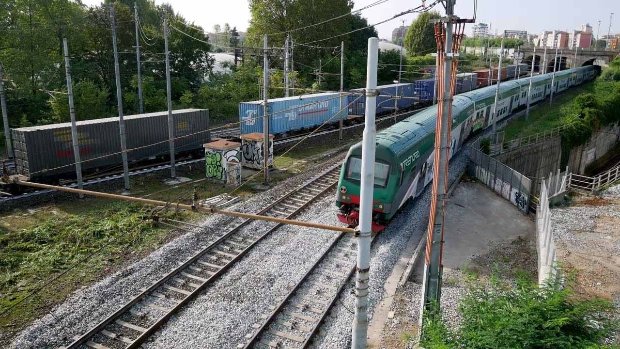 Intermodal train hauled by MercItalia Rail's E494 012, running parallel with a Trenord Vivalto