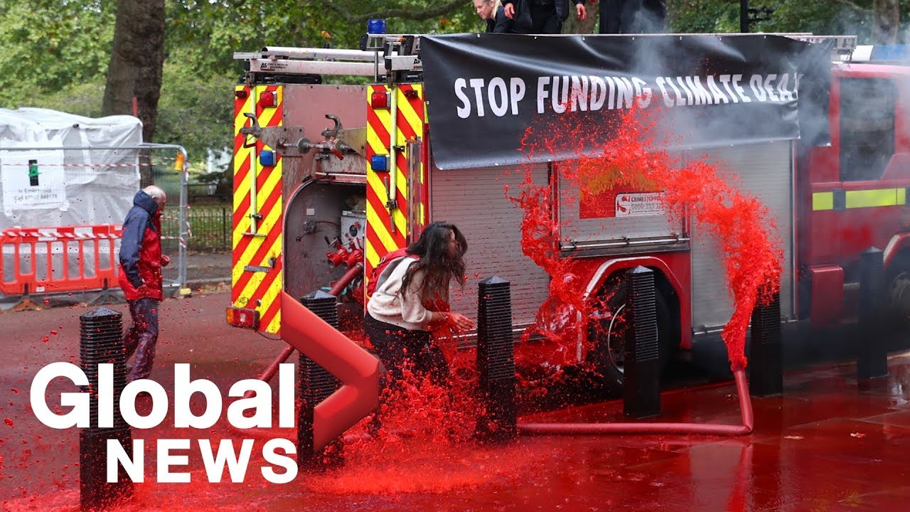 Climate activists lose control of fire hose while spraying 'fake blood' on UK Treasury