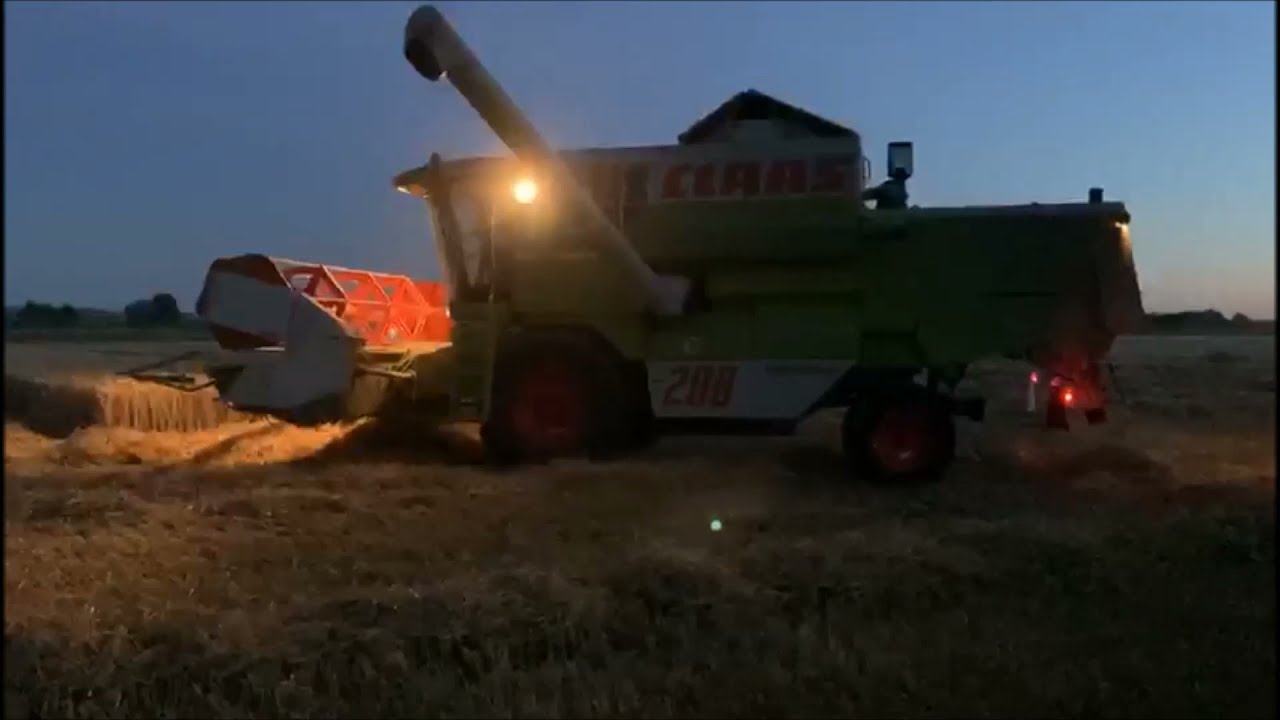 Claas Dominator 208 Mega beim dreschen und abbunkern in der Abbenddämmerung