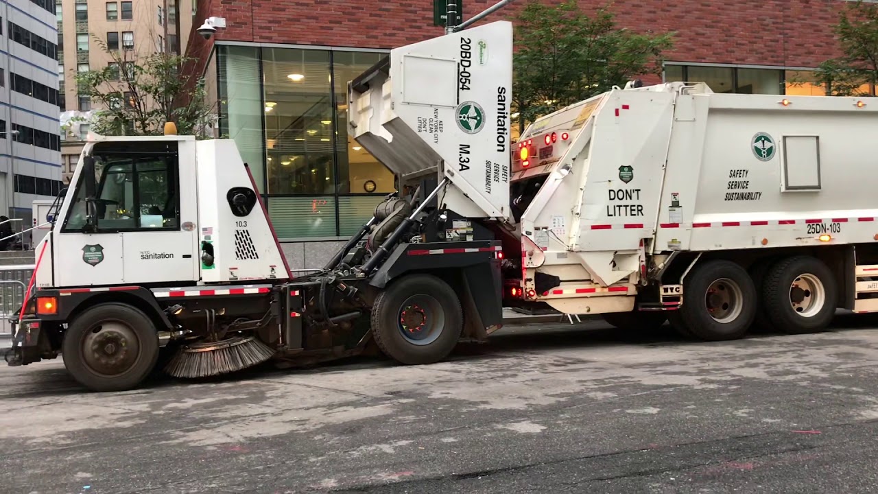 RARELY SEEN PROCEDURE OF A DSNY STREET SWEEPER EMPTYING CONTENT INTO A DSNY GARBAGE COLLECTION TRUCK