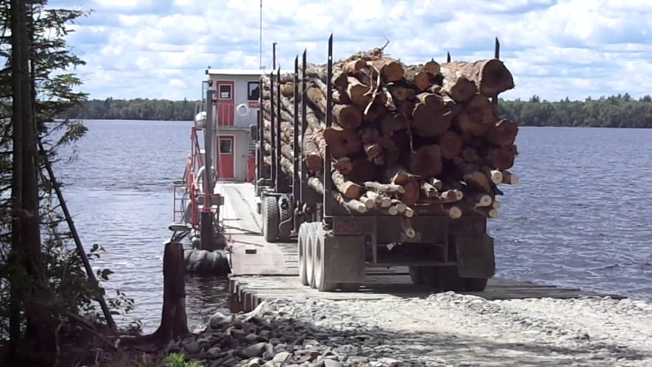 2013 loaded logging truck driving on to barge on Moosehead Lake, Maine
