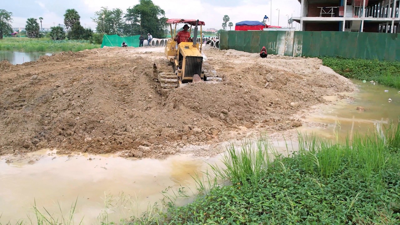 Starting a new project with a Komatsu D31p bulldozer pushing soil into a lake