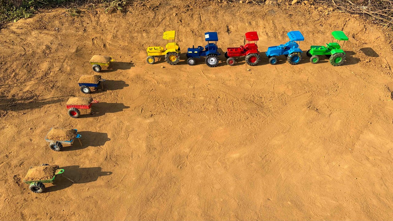 The tractor trailers are filled with soil, and tractors have come to pick them up.#161