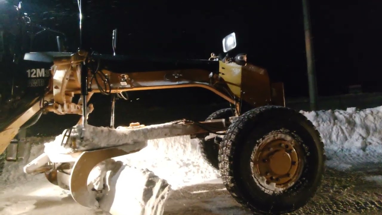 コマツGD675モーターグレーダー除雪車と、日本キャタピラモーターグレーダー除雪車で、除雪中