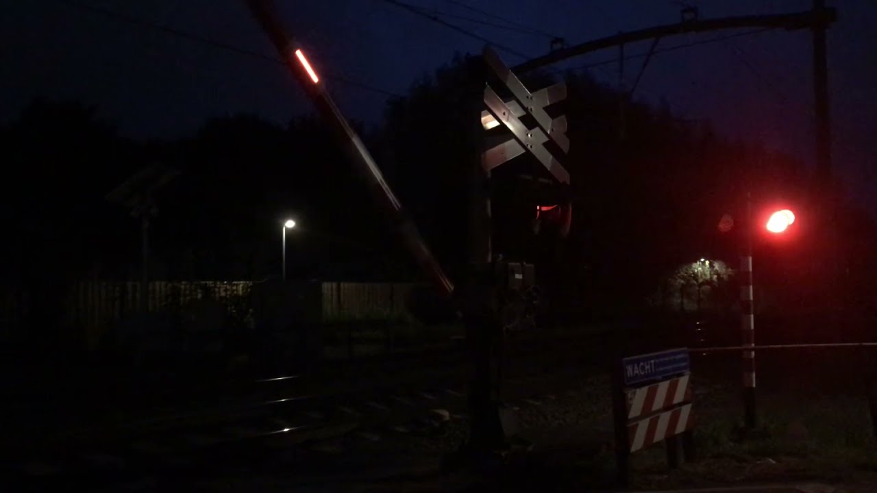 2 treinen komen langs bij Overweg Breda-Prinsenbeek in de avond