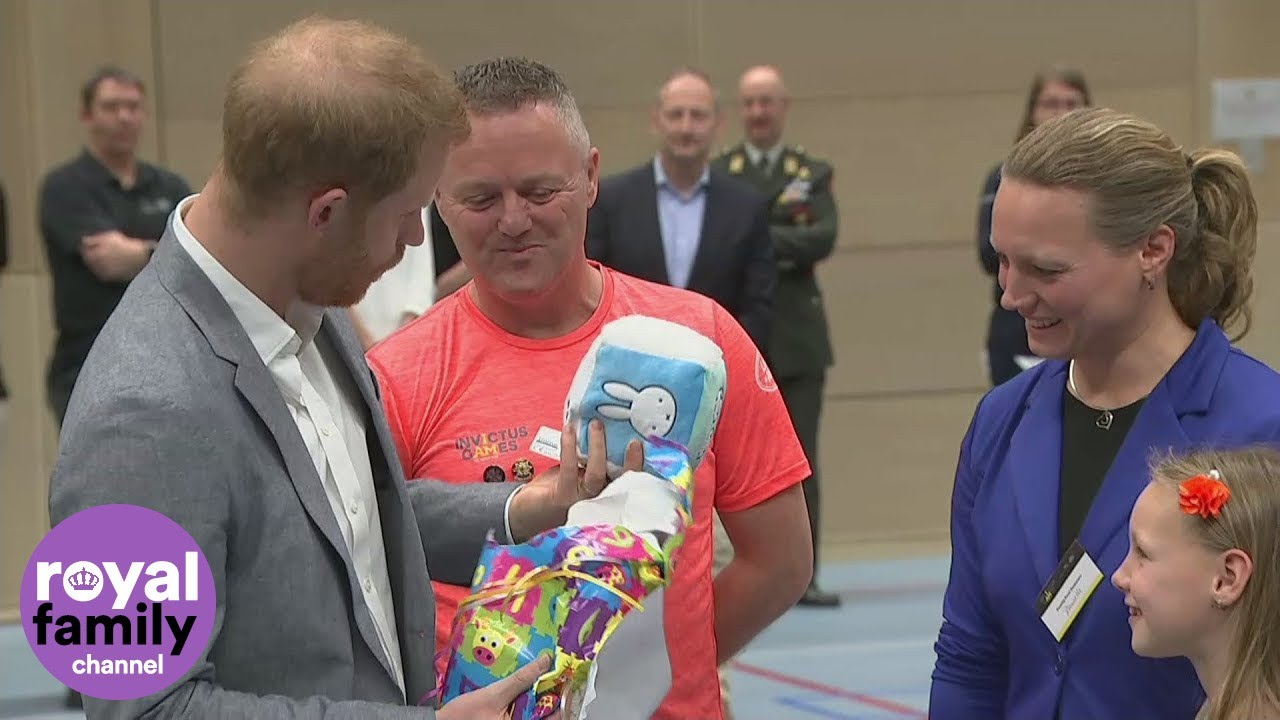 The Duke of Sussex unwraps a present for three-day-old Archie