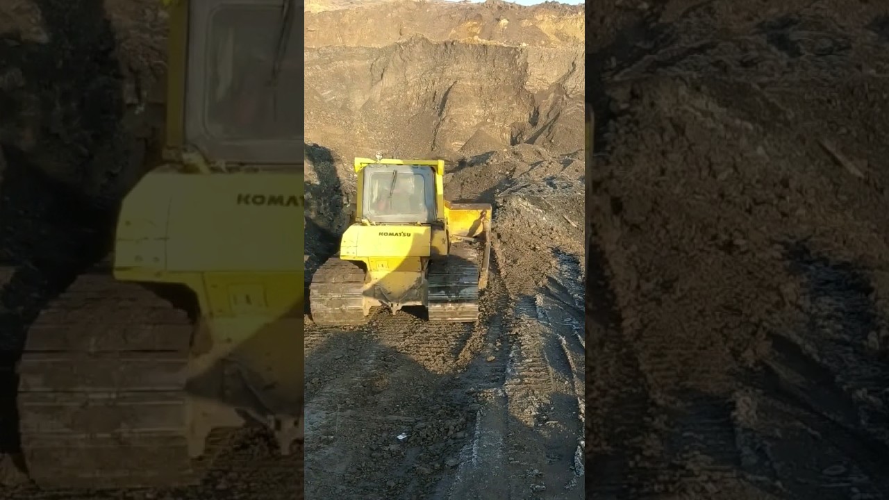 KOMATSU bulldozer leveling dirt road at the coal mine