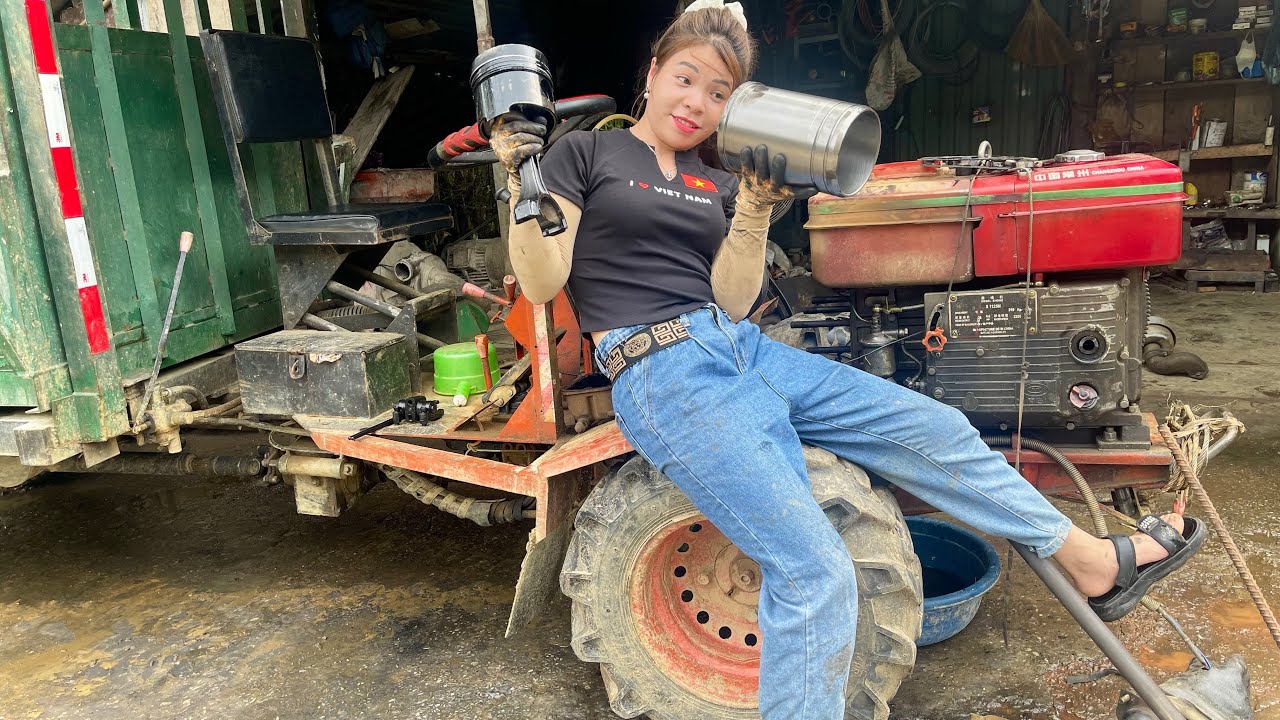 Girl mechanic repairs and replaces tractor engine block