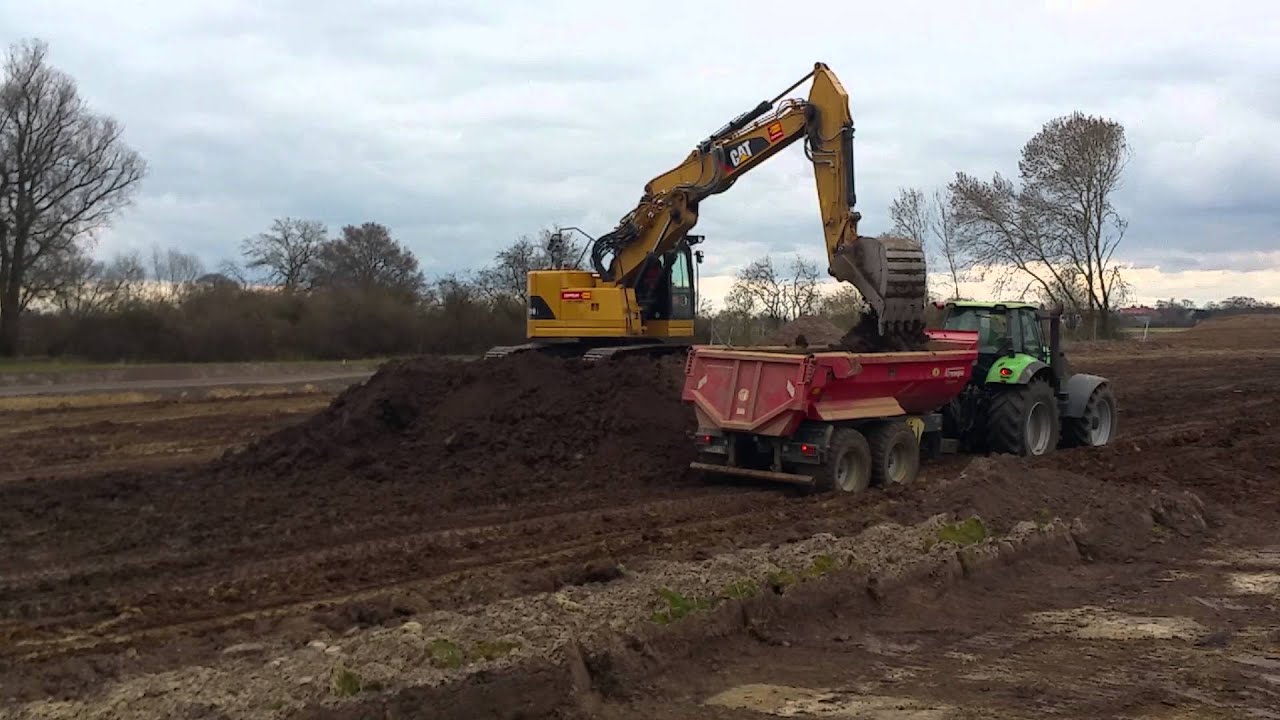 CAT 321D loading DEUTZ Traktor with dumptrailer