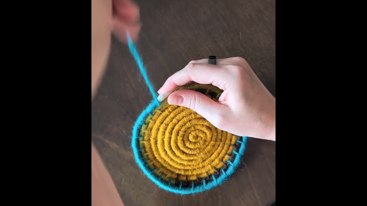 Wrapping macrame cord with wool yarn to make a coiled basket. 