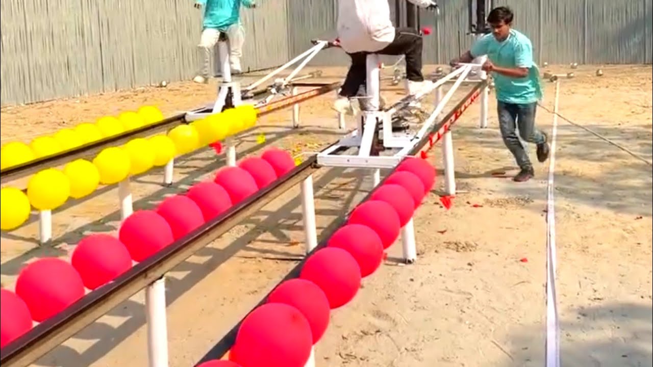 Two young people won the prize in the funny game of bursting balloons by pushing the toy people