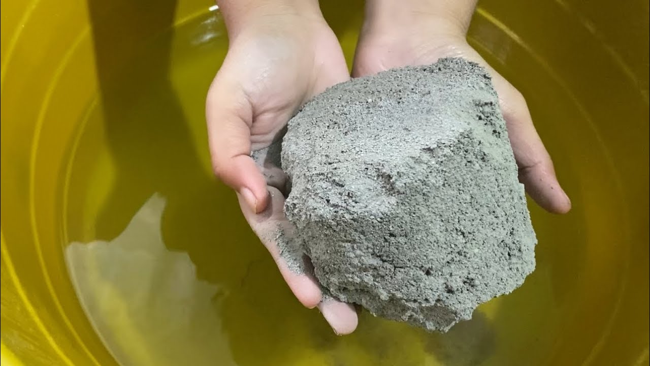 Buttery black sand melting in hands water crumbling 