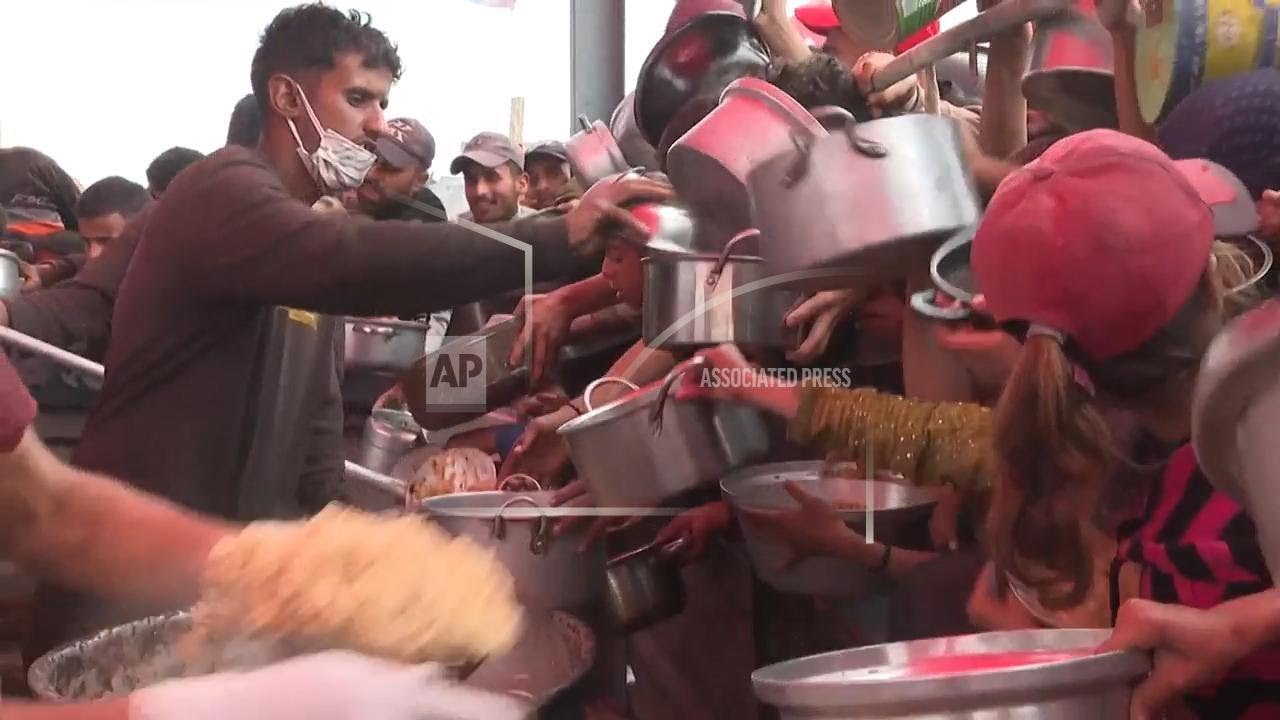 Dozens in Khan Younis crowd aid kitchen in hope of getting at least one meal for their families