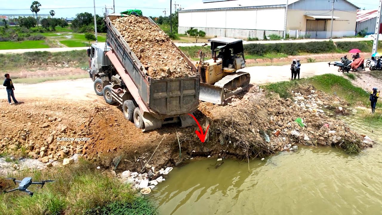 GREAT !! Heavy dump truck 25Ton unloading soil landfilling flooded with Huge bulldozer working push 