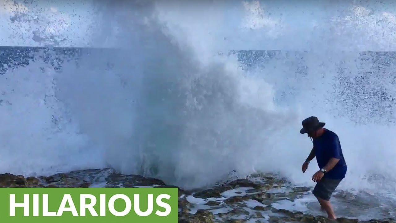 Prankster wife tricks husband into getting splashed by wave