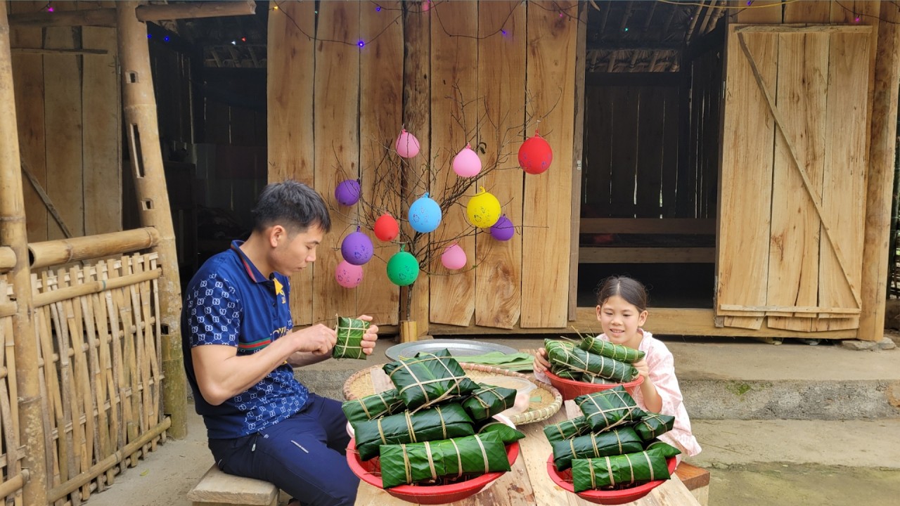The uncle and little Thu wrapped the banh chung (traditional Vietnamese rice cakes) for Tet.