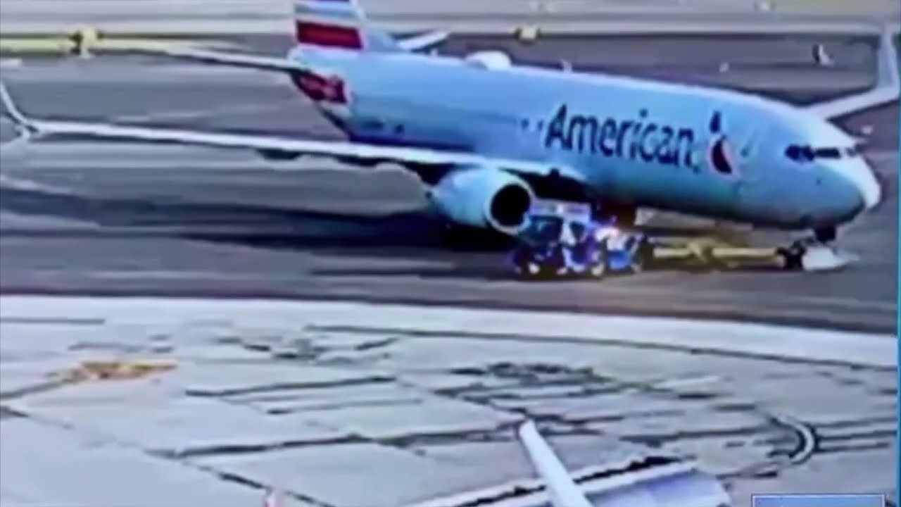 American Airlines plane runs over and crushes towing vehicle.