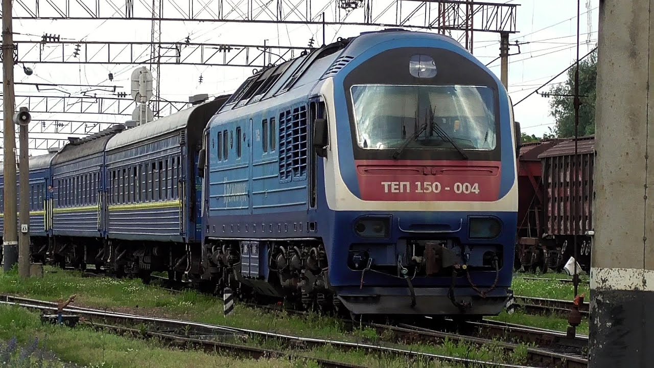 Тепловоз ТЭП150-004 подаёт пригородный поезд для посадки по станции Ромодан