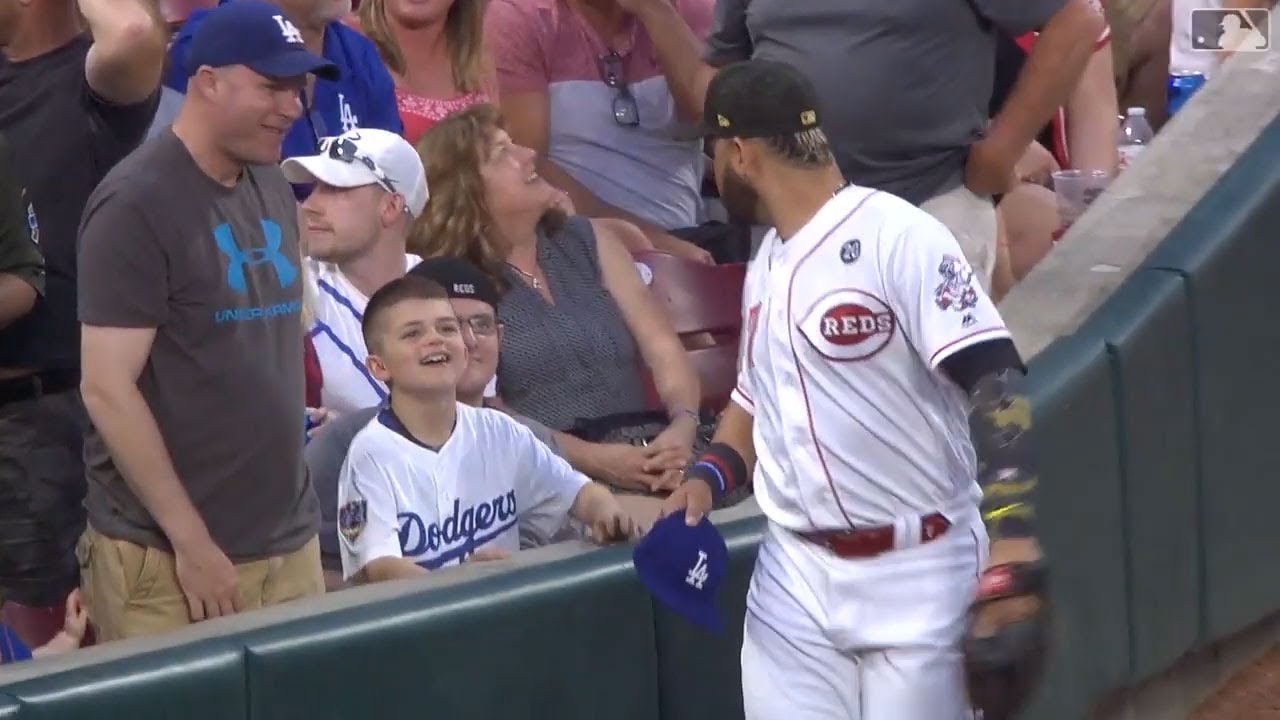Eugenio Su&aacute;rez takes a young Dodgers fan's hat