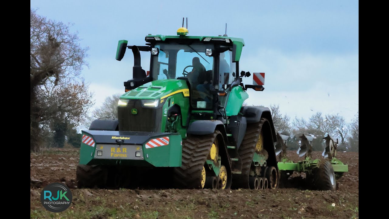 john deere  caterpillar tractor ploughing up a sugerbeet field