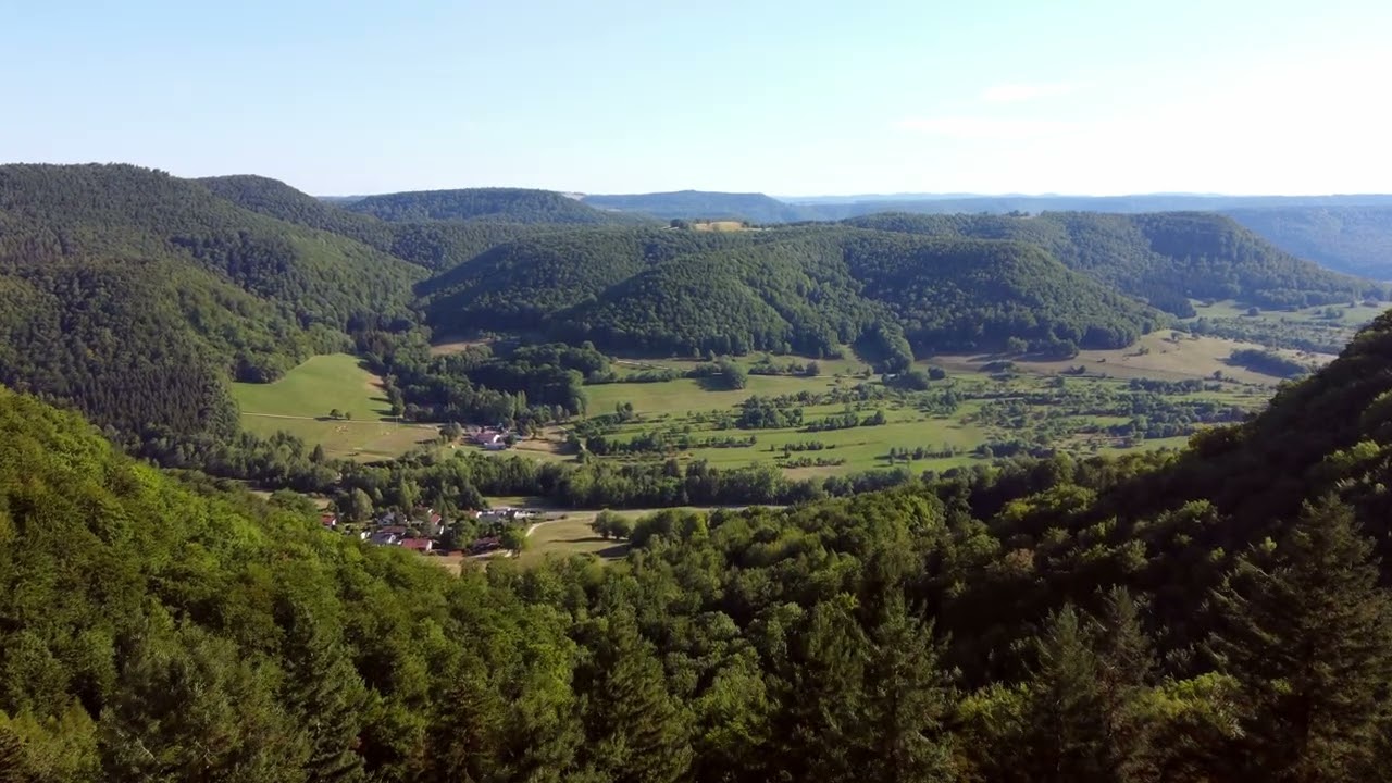 Forward flight over trees revealing scenic valley in the Swabian Alps in Southern Germany