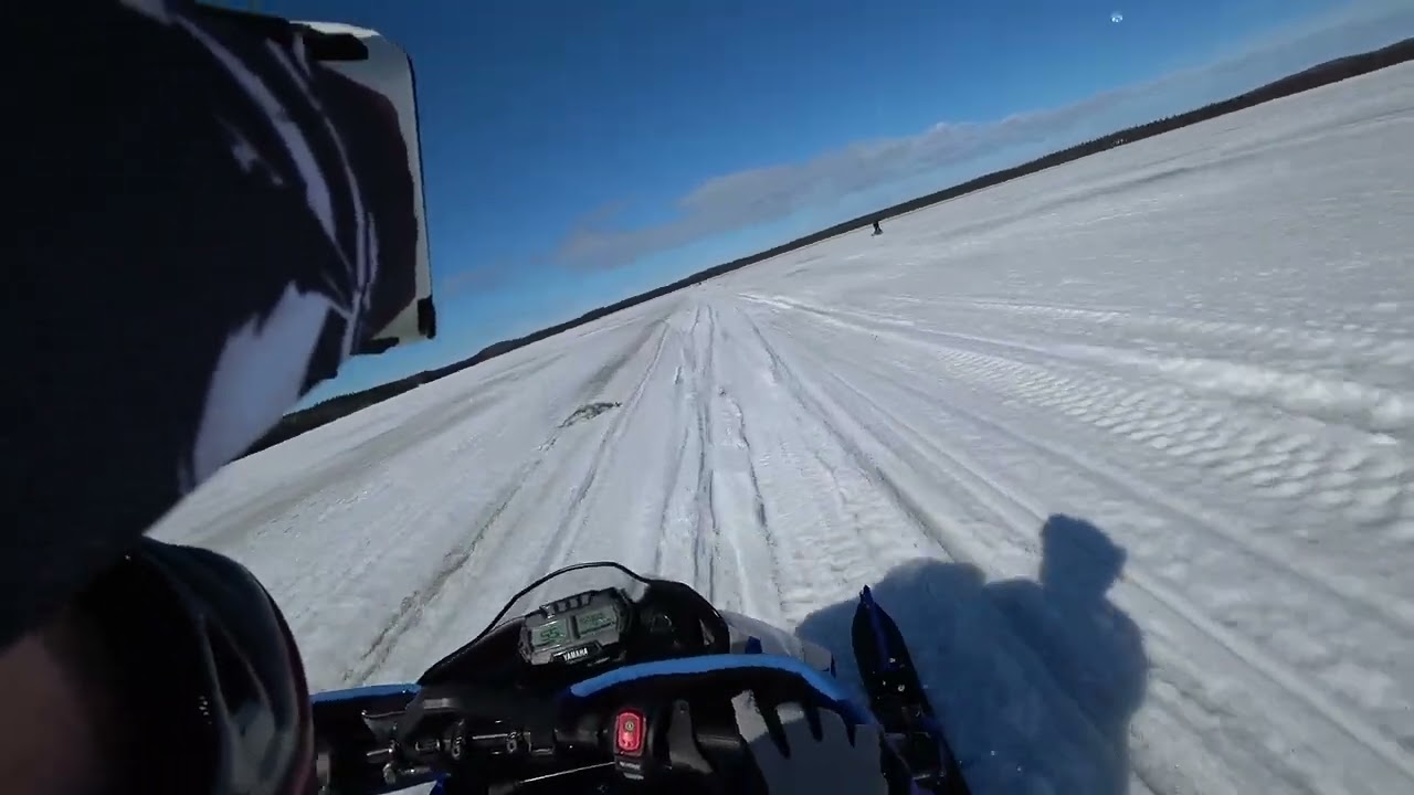 Skoter körning över kypasjärvi sjön i blöt snö