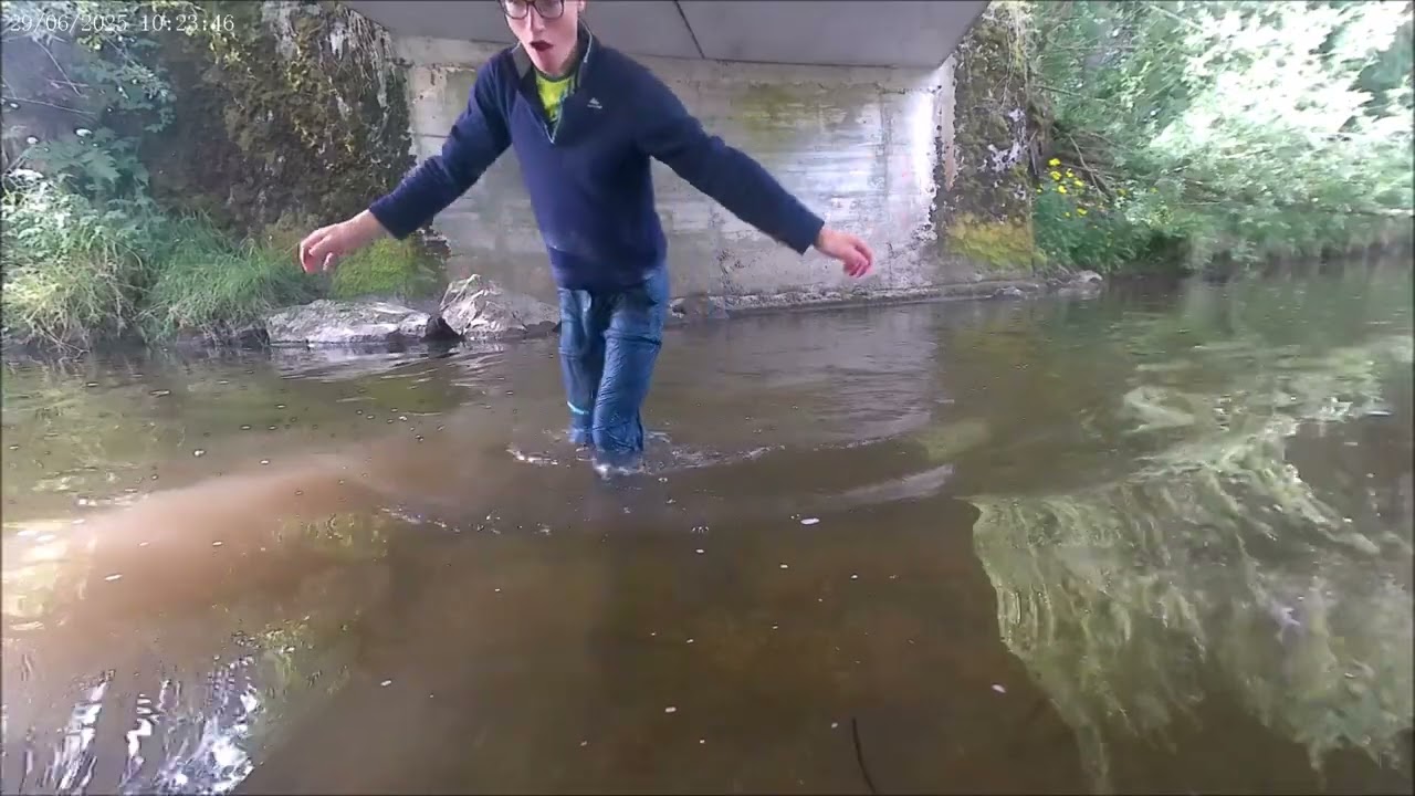 Kind geht mit Klamotten ins Wasser 