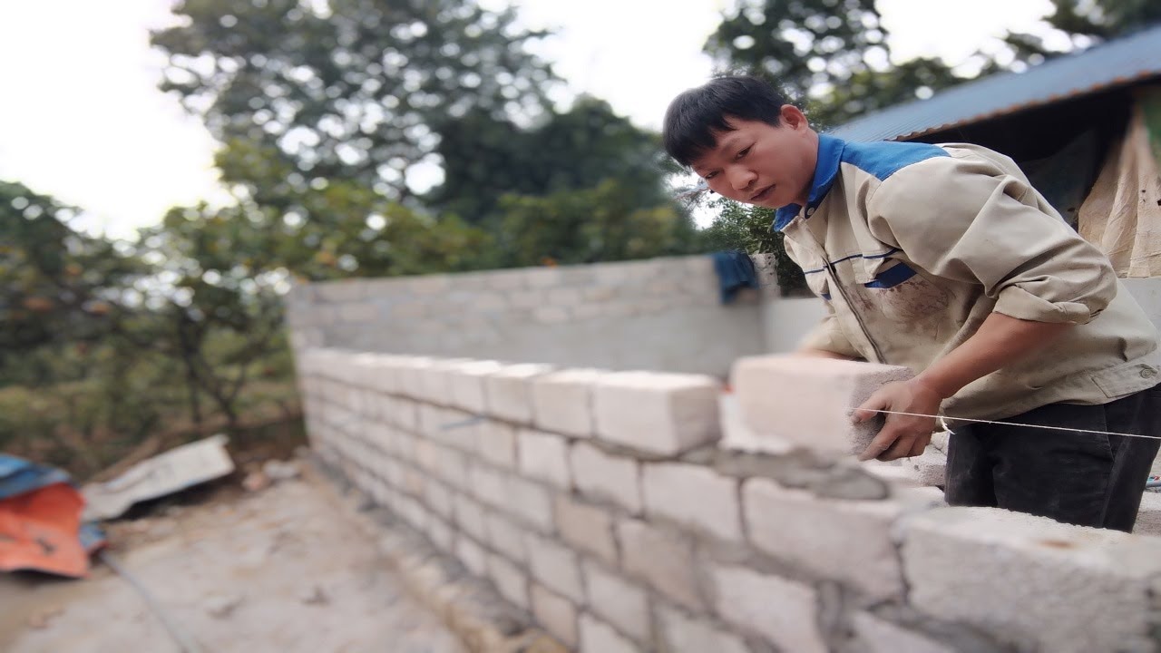 Phụ hồ  một mình xây chuồng lợn