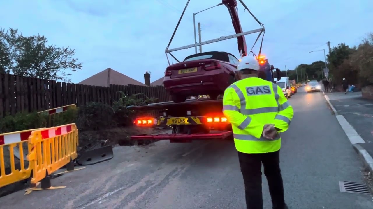 Car goes down hole due to someone jumping red light 