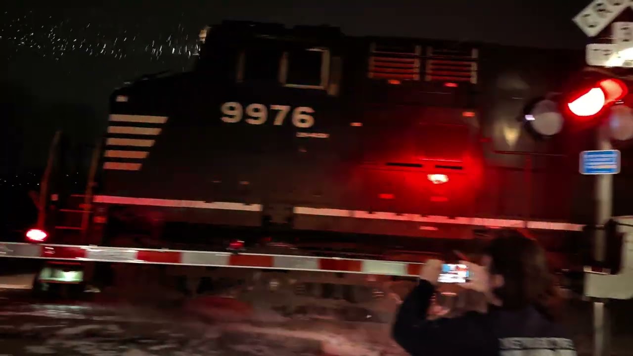 A pair of C44-9W locomotives are hauling a NS intermodal train during a snow storm.