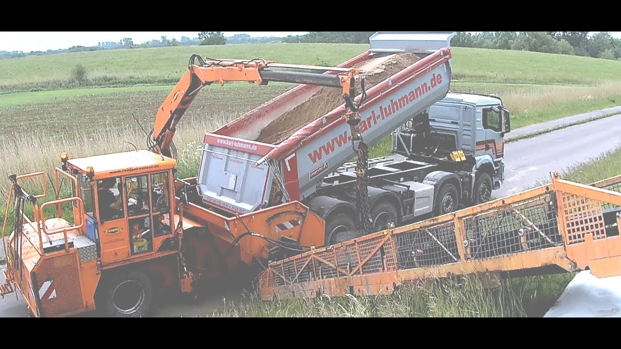 Minibagger Yanmar SV26 und Spezial Umlader beim Frostschutzkies einbauen auf dem Deich in Wendtorf