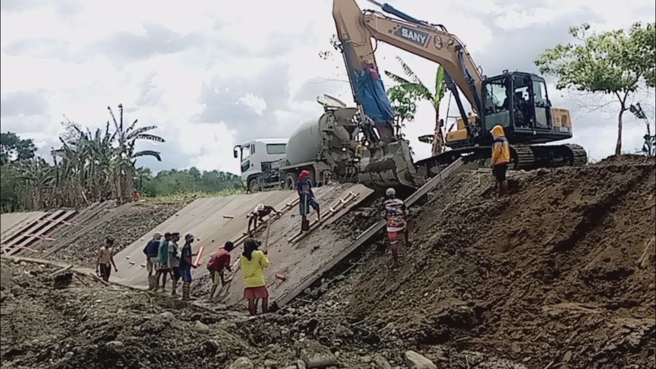 SANY SY215C Excavator Pouring concrete for river slope protection structure along. alibunan River